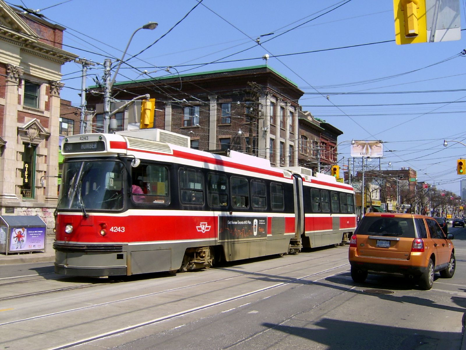A streetcar passing independent storefronts on Queen Street West, Toronto, in 2008